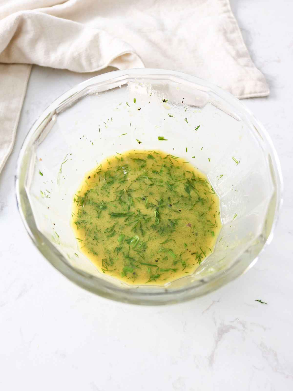 Making the salad dressing in a glass bowl.