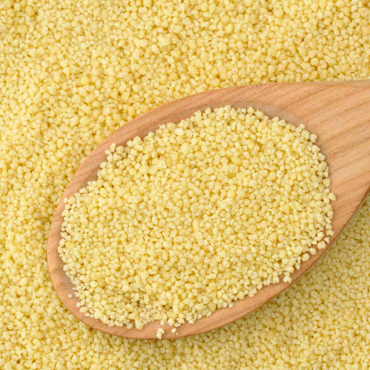 Couscous on a wooden spoon.