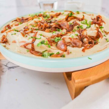 Mashed onions in a plate topped with green parsley.