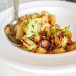 onions and potatoes served on a white plate.