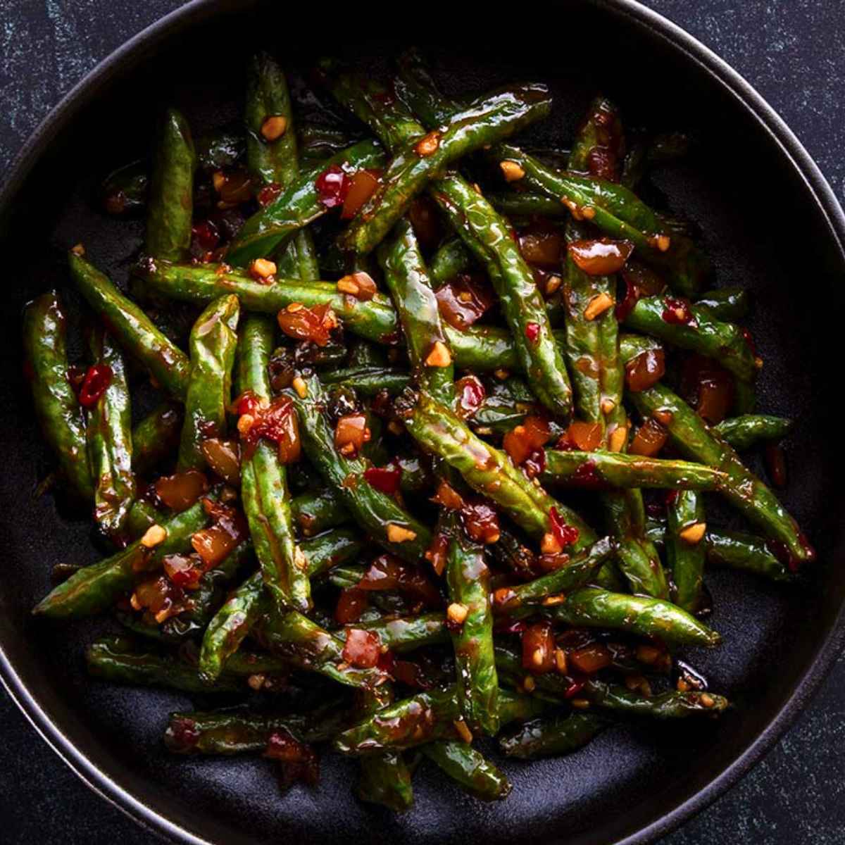 Vegan Chili Garlic Green Beans served on a black plate.