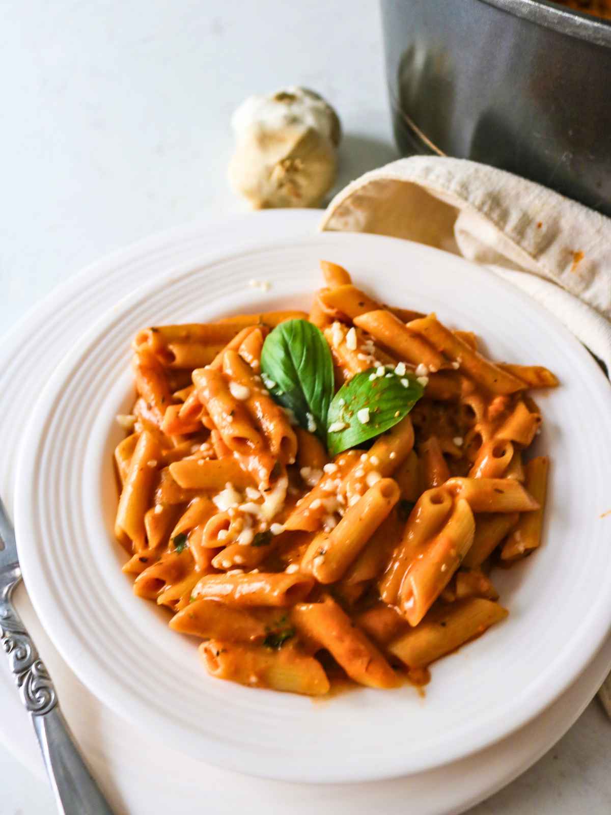 Roasted tomato pasta served in a white plate.