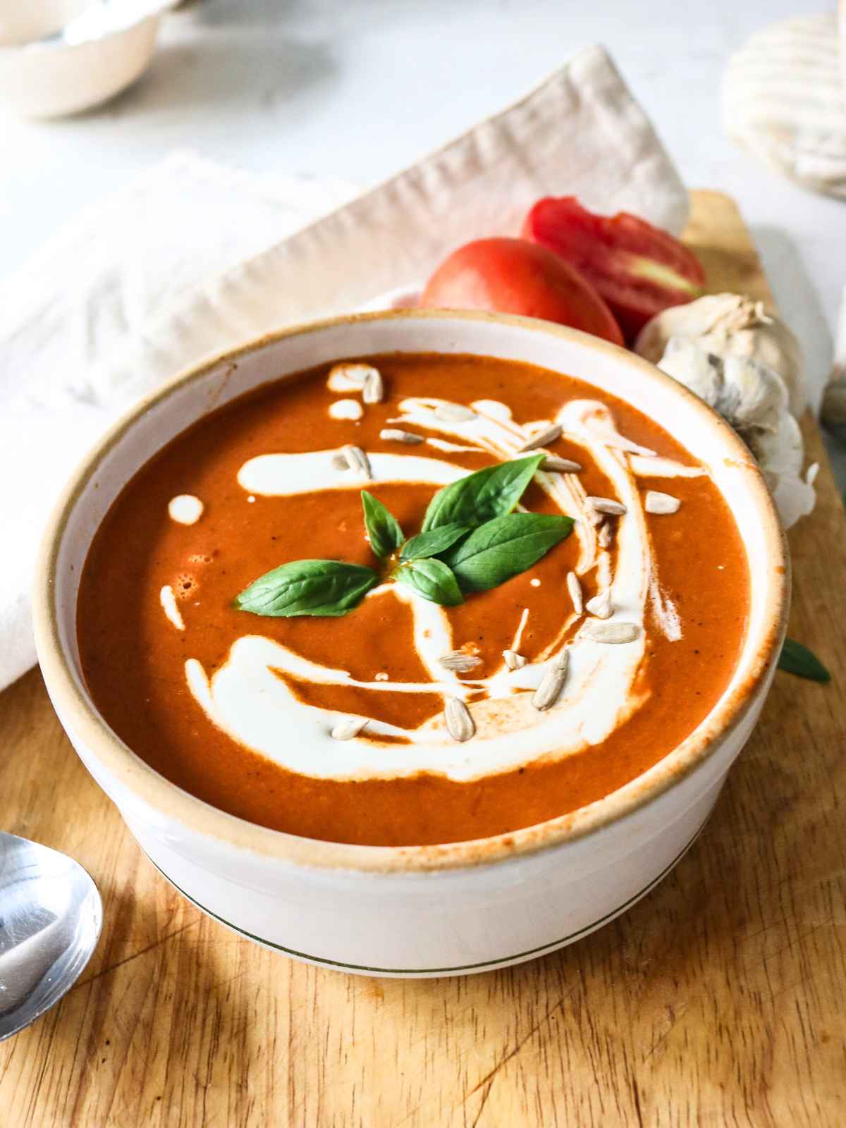 Tomato soup topped with cream and basil leave.