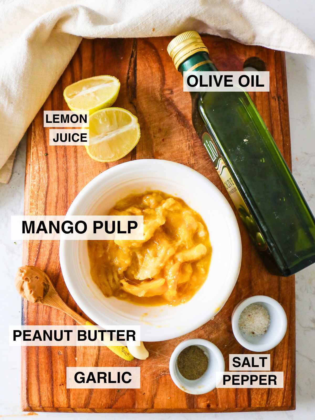 Ingredient to make mango salad dressing placed on a wooden board.