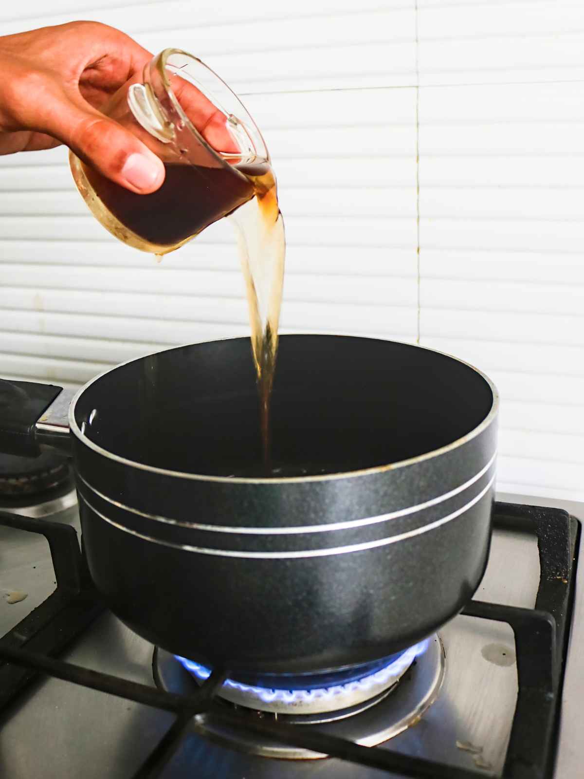 Pouring balsamic vinegar in a saucepan.